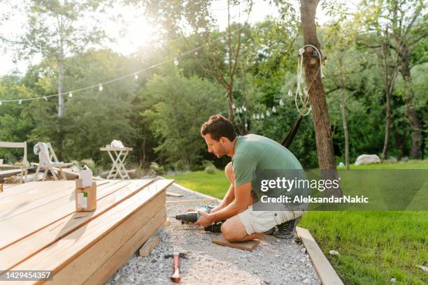schreiner beim einbau von terrassendielen - terrassenboden stock-fotos und bilder