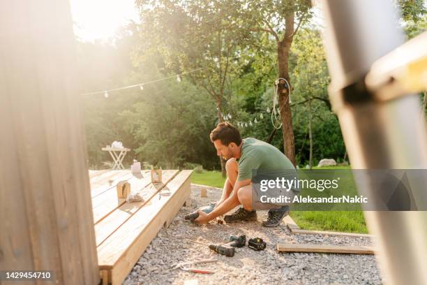 carpenter installing decking boards - renovatie stockfoto's en -beelden