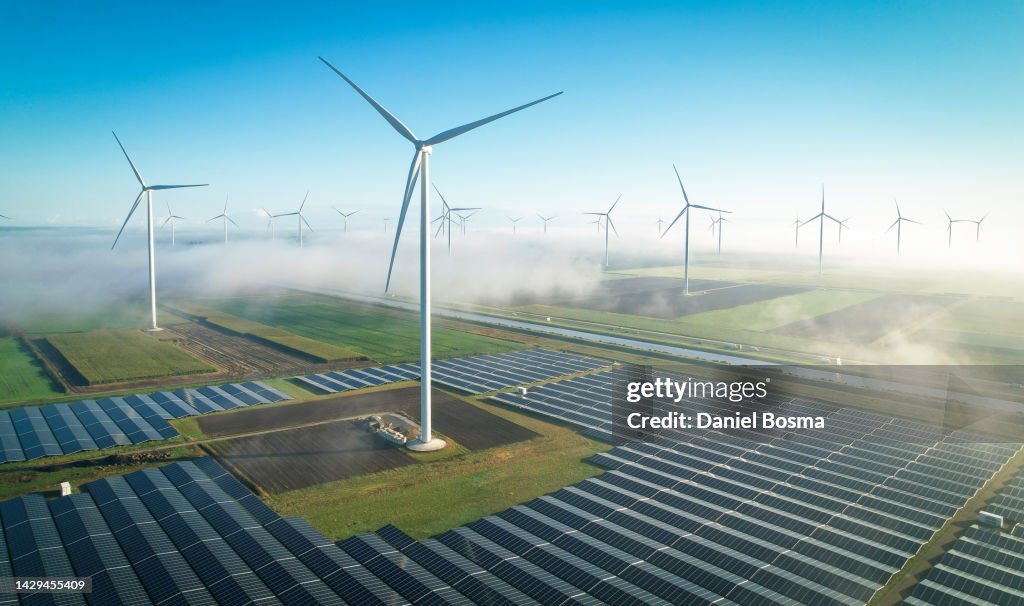Solar energy and wind turbines in fog, seen from the air