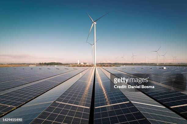 reflection of wind turbines on solar panels - symmetry stock pictures, royalty-free photos & images
