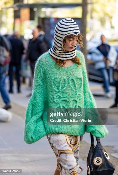 Katerina Tannenbaum wears baclava green knitted jumper, skirt with graphic print outside Loewe during Paris Fashion Week - Womenswear Spring/Summer...