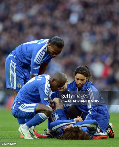 Chelsea's Didier Drogba and Ramires lean over teammate David Luiz after he was injured against Tottenham Hotspur during the FA Cup semi-final...