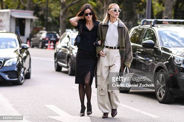 Alex Riviere is seen wearing a Hermes blue shirt and skirt with black sunglasses and black and silver heels with Viktoria Rader is seen wearing a...