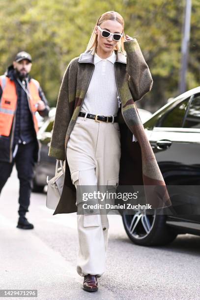 Viktoria Rader is seen wearing a gray and green Hermes coat, Hermes white top, tan Hermes pants, brown shoes and white sunglasses outside the Hermes...