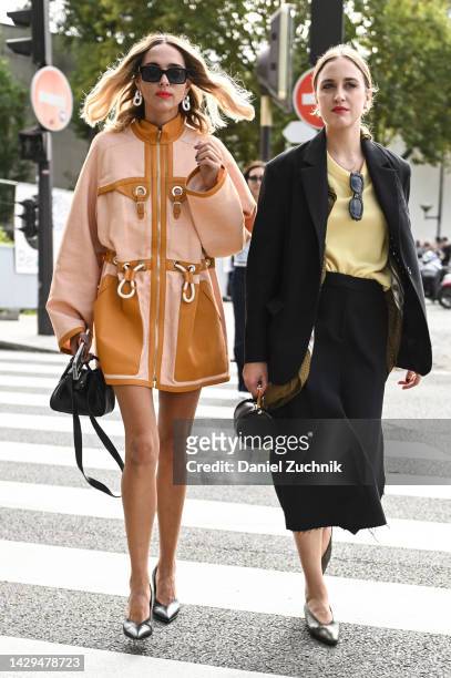 Candela Pelizza is seen wearing a tan and light pink Hermes coat, black sunglases, silver hoop earrings and black bag outside the Hermes show during...