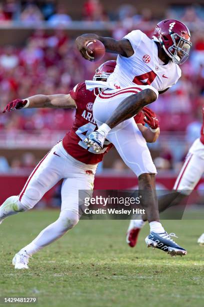 Jalen Milroe of the Alabama Crimson Tide tries to avoid the tackle from Drew Sanders of the Arkansas Razorbacks during the second half at Donald W....