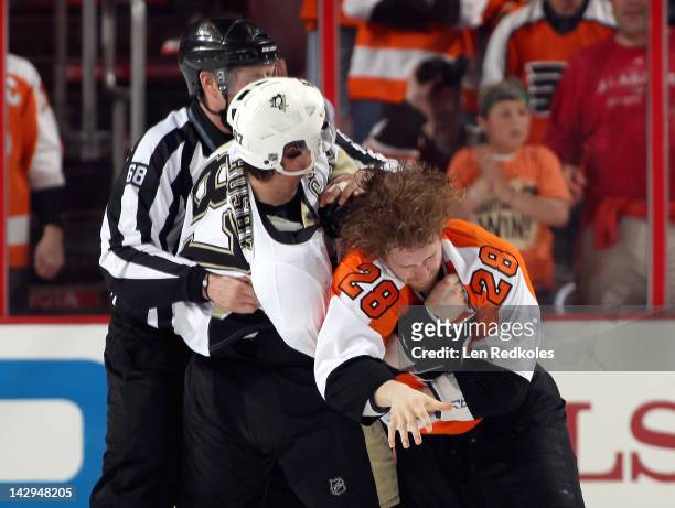 Linesman Scott Driscoll attempts to break up a fight in the first period between Claude Giroux of the Philadelphia Flyers and Sidney Crosby of the...