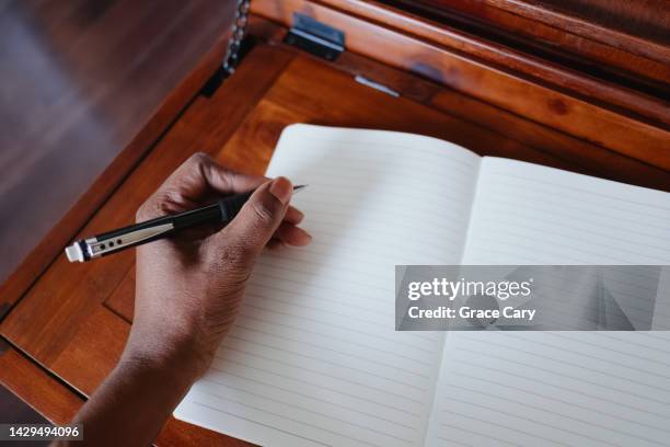 woman writes in empty notebook - links stock-fotos und bilder