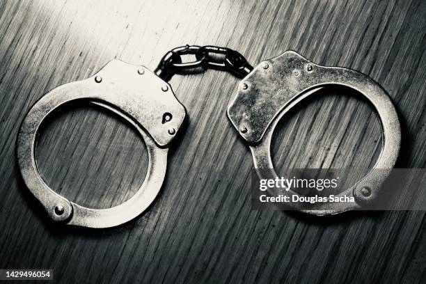 incarceration concept - closed handcuffs - arresto foto e immagini stock