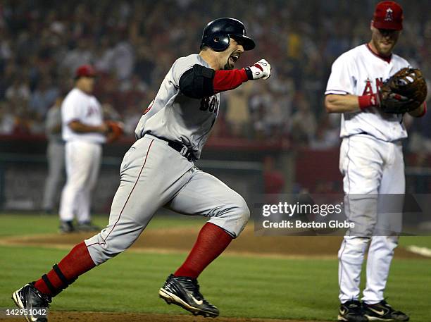 Red Sox player Jason Varitek, center, exults as he rounds first base when he realizes he has just hit a two run home run off of Angel pitcher Bartolo...