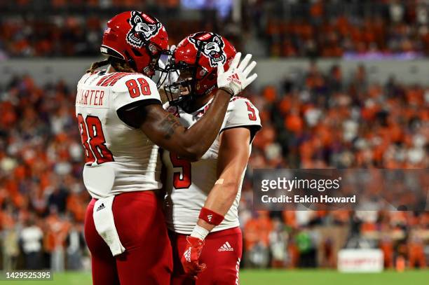 Thayer Thomas and Devin Carter of the North Carolina State Wolfpack celebrate a play against the Clemson Tigers in the first quarter of the game at...