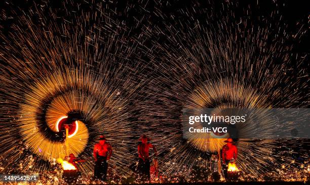 Tourists watch molten iron fireworks at a scenic spot on China's National Day on October 1, 2022 in Huaibei, Anhui Province of China. The weeklong...