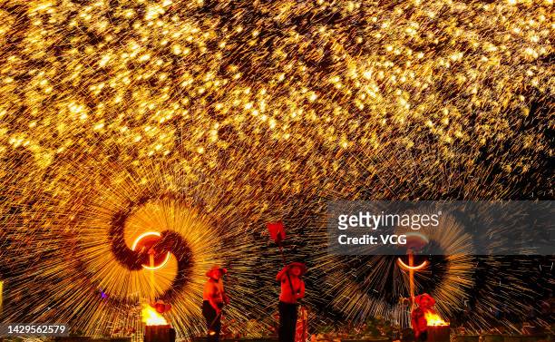 Tourists watch molten iron fireworks at a scenic spot on China's National Day on October 1, 2022 in Huaibei, Anhui Province of China. The weeklong...