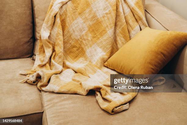 crumpled covering and cushion on couch. - yellow sofa stock pictures, royalty-free photos & images