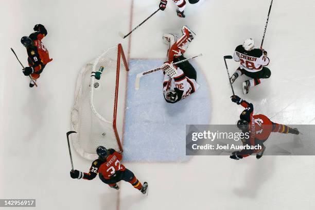 Goaltender Martin Brodeur of the New Jersey Devils looks back at the puck in the net as Stephen Weiss scores and Kris Versteeg and Tomas Fleischmann...