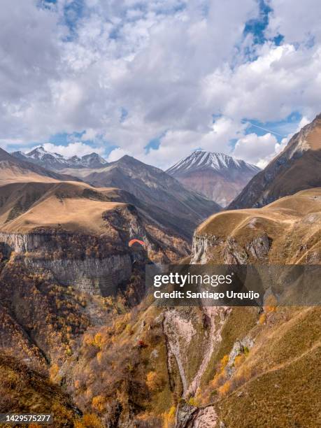 paragliding by the georgian military road at gudauri - hang parachute stock-fotos und bilder