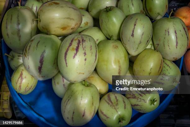 pepino fruits in a market stand in urla. - pepino stock-fotos und bilder