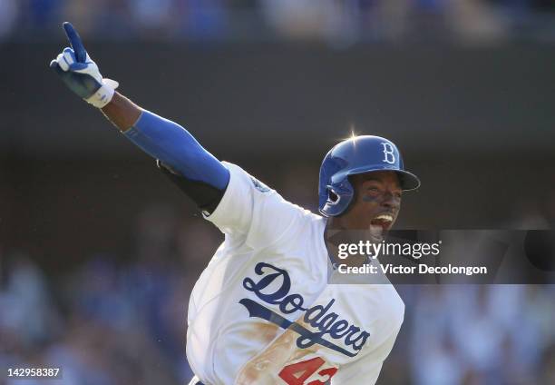 Dee Gordon of the Los Angeles Dodgers runs to first base celebrating his 9th inning game-winning single against the San Diego Padres during the MLB...