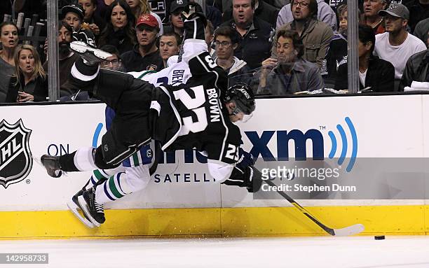 Dustin Brown of the Los Angeles Kings and Kevin Bieksa of the Vancouver Canucks collide against the boards in Game Three of the Western Conference...