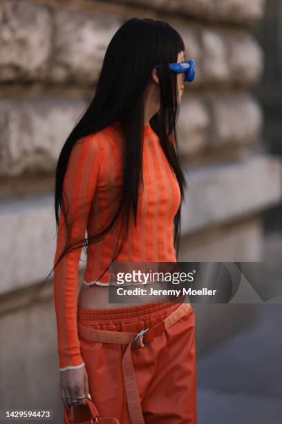 Irene Kim guest seen wearing a total orange Loewe look with blue Loewe sunglasses, outside Loewe during Paris Fashion Week on September 30, 2022 in...