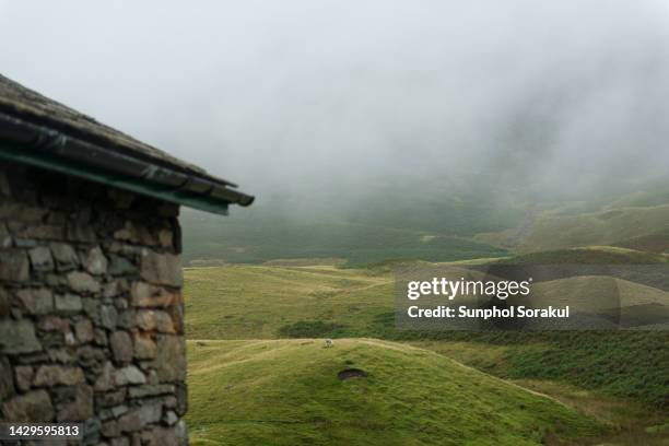 stone cottage and hilly landscape of the lake district area, cumbria, uk - montanhas cumbrianas - fotografias e filmes do acervo