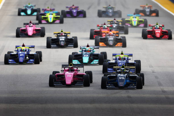 SINGAPORE, SINGAPORE - OCTOBER 02: Beitske Visser of Netherlands and Sirin Racing (95) and Marta Garcia of Spain and CortDAO W Series Team (19) lead the field into turn one at the start during the W Series Round 6 race at Marina Bay Street Circuit on October 02, 2022 in Singapore, Singapore.