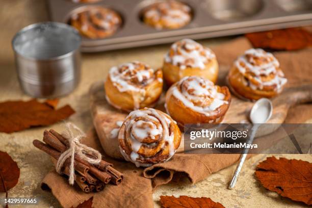 homemade pastry cinnamon roll buns in rustic autumn kitchen with fresh icing sugar - coffee cake stock pictures, royalty-free photos & images