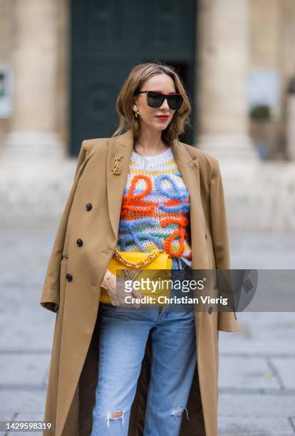 Alexandra Lapp wears Medeea long coat in beige, Agolde destroyed denim in light blue, Loewe mohair knit sweater in multicolor, Louis Vuitton Twist MM...