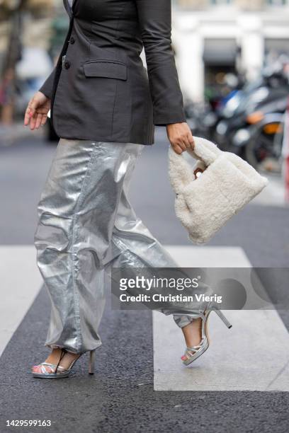 Carolina Ogliaro wears Polene bag, Gucci sunglasses, silver pants, blazer, Jimmy Choo heels, APM Monaco jewelry outside during Paris Fashion Week -...