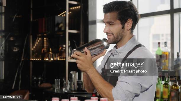 asian bartender mixing a drink in bar - bar man t shirt ストックフォトと画像