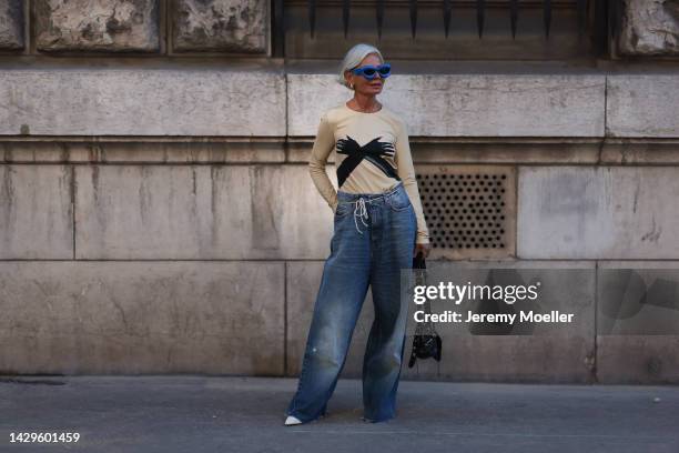 Grece Ghanem seen wearing a Loewe shirt and sunglasses by Loewe with a balenciaga le cagole bag, outside Loewe during Paris Fashion Week on September...