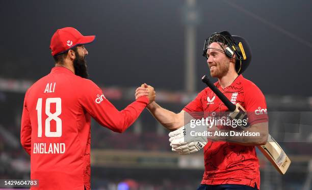 Phil Salt of England celebrates with Moeen Ali after the 6th IT20 between Pakistan and England at The Gadaffi Stadium on September 30, 2022 in...