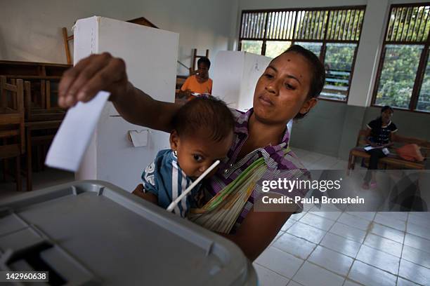 An East Timorese mother holds her baby as she votes in the run-off Presidential elections on April 16, 2012 in Dili, East Timor. The second round...