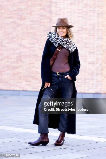Influencer Gitta Banko, wearing a brown hat by Stetson, a black Jeans by Balenciaga, a black belt and dark brown cowboy boots by Celine, a brown...