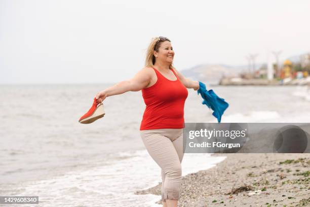 fröhliche verrückte übergewichtige frau - dicke frauen am strand stock-fotos und bilder