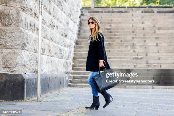 Influencer Gitta Banko, wearing a black balzer by Gitta Banko The Label, a black and white striped shirt by H&M, a Jeans by Dsquared2, black cowboy...