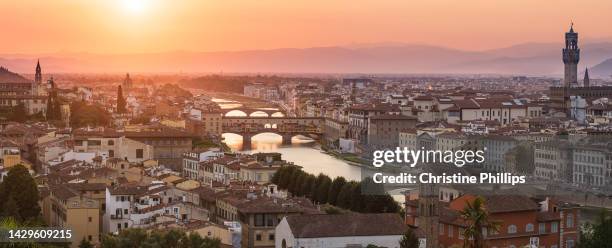 a panoramic view of the skyline of florence, tuscany, italy, at sunset with its many bridges crossing the river arno. in view is the historic ponte vecchio, one of the oldest remaining bridges of its kind. - ponte vecchio bildbanksfoton och bilder