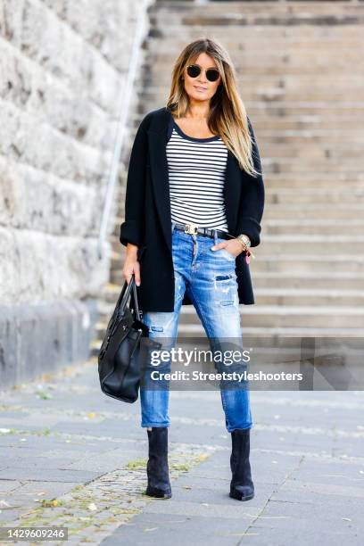 Influencer Gitta Banko, wearing a black balzer by Gitta Banko The Label, a black and white striped shirt by H&M, a Jeans by Dsquared2, black cowboy...