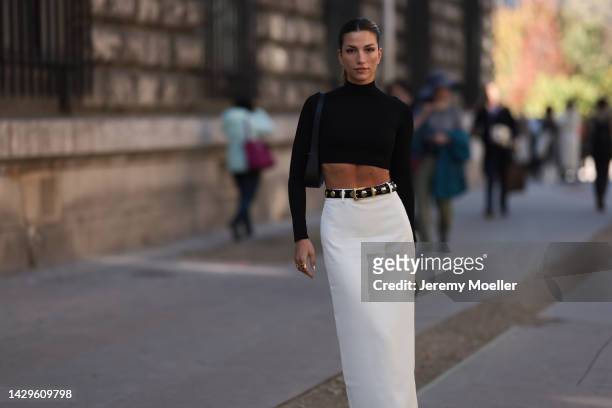 Cassandra Dimicco seen wearing a black croptop and a long white skirt with black plateau leather boots, outside Loewe during Paris Fashion Week on...