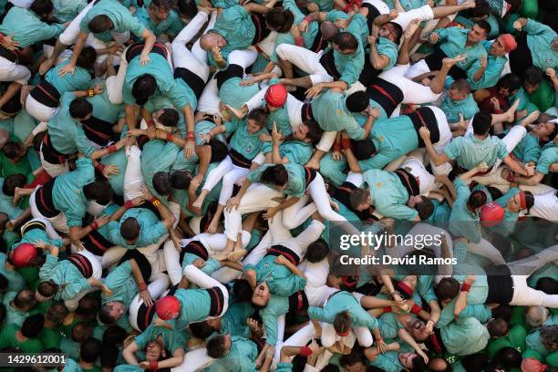 Members of the colla 'Castellers de Vilafranca' fall down ad they build a human tower during the 28th Tarragona Competition on October 2, 2022 in...