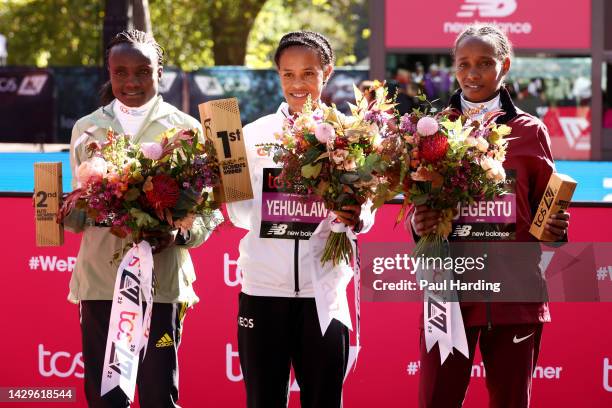 Second placed Joyciline Jepkosgei of Kenya, first placed Yalemzerf Yehualaw of Ethiopia and third placed Alemu Megertu of Ethiopia pose for a photo...