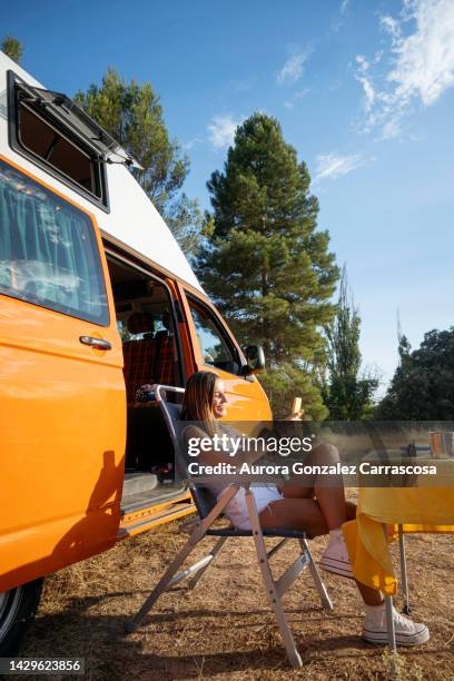 adult woman with her son and daughter having a fun family day at a campsite with their orange van - camping games stockfoto's en -beelden