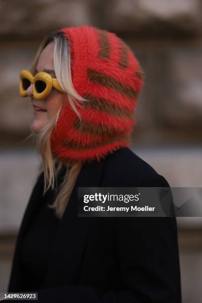 Fashion week guest seen wearing a cozy balaclava and yellow Loewe sunglasses, outside Loewe during Paris Fashion Week on September 30, 2022 in Paris,...