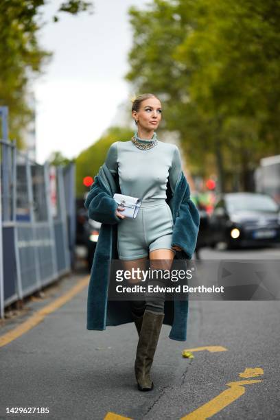 Leonie Hanne wears silver earrings, a gold large chain necklace, a silver large chain necklace, a pale gray turtleneck pullover from Hermes, matching...