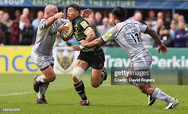 George Pisi of Northampton is tackled by George Chuter and Manu Tuilagi during the Aviva Premiership match between Northampton Saints and Leicester...