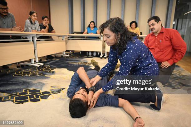 instructor teaching recovery position in a first aid training class - recovery position stock pictures, royalty-free photos & images