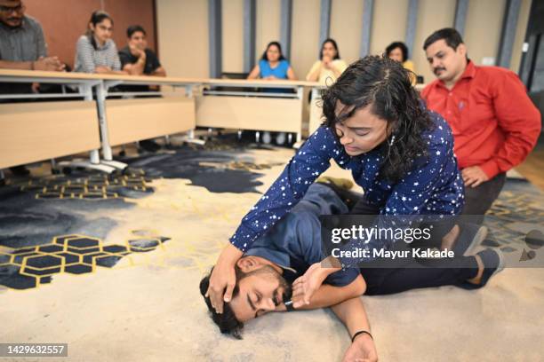instructor teaching recovery position in a first aid training class - recovery position stock pictures, royalty-free photos & images