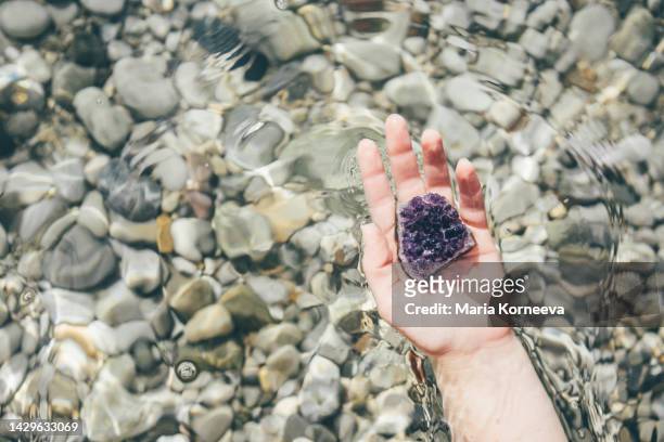 woman holding crystals at transparent clear water. - healing prayer images stock pictures, royalty-free photos & images
