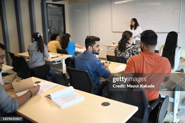 female instructor teaching mature adult students in the classroom - demonstration stock pictures, royalty-free photos & images