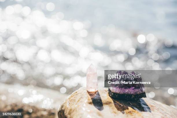 crystal on beach against sea. - kristallheilung stock-fotos und bilder